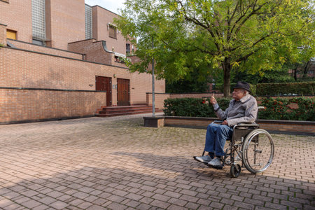 Disabled senior man in wheelchair outdoorsの写真素材