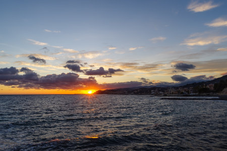 Clouds at sunset with cityscape silhouette - Imperia, Liguria, Italyの写真素材
