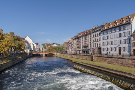 Strasbourg, France - October 25, 2021: Ill River canal with promenade and row of town houses