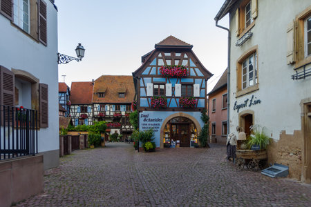 Eguisheim, France - October 24, 2021: View along cobblestone street in the historic village of Eguisheim surrounded well-preserved half-timbered buildings, Alsace region in Eastern Franceのeditorial素材