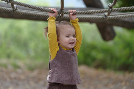 A 18 months old baby girl in a playground outdoors