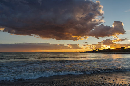 Dramatic colorful clouds at sunset with cityscape silhouette, Imperia, Liguria, Italyの写真素材