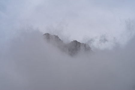 Rocky mountain peaks come out of the clouds, Maira Valley, Italian Cottian Alps