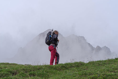 Mountain hiker in Maira Valley, Italian Cottian Alps, during trek in summer. Cottian Alps mountain range in the southwestern part of the Alps, borders between France and Italy. In this Alpine Valley, Nature is wild and majestic.の写真素材