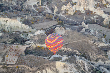 Hot air balloon flying over rock landscape at Cappadocia, Turkeyの写真素材