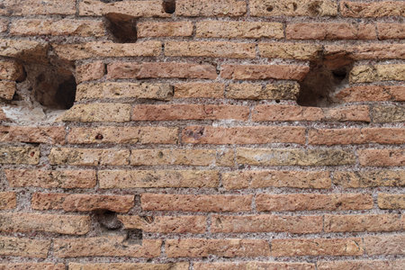 Weathered ancient Roman brick wall revealing aged surface, eroded details, historical architectural texture, Colosseum, Rome, Italyの写真素材