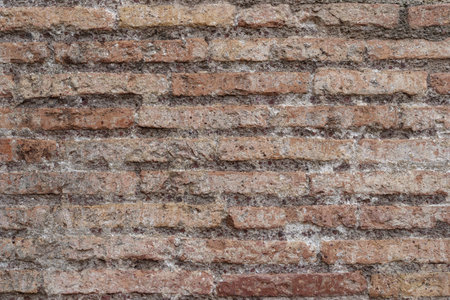 Weathered ancient Roman brick wall revealing aged surface, eroded details, historical architectural texture, Colosseum, Rome, Italyの写真素材