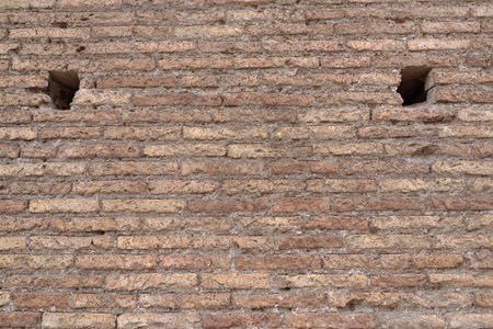 Weathered ancient Roman brick wall revealing aged surface, eroded details, historical architectural texture, Colosseum, Rome, Italyの写真素材