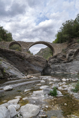 Old stone arch bridge in Ligurian Alps mountains, Molini di Triora municipality, Imperia province, Italyの写真素材