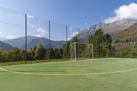 A green field of football backed by forest and mountains, Italyの写真素材