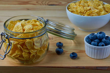 Cornflakes with milk for breakfast. Blueberries. Wood background.の写真素材