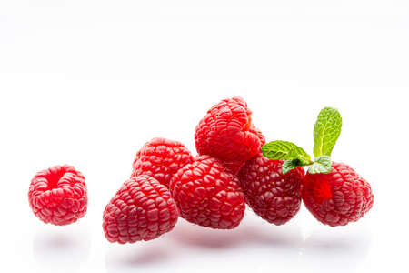 Ripe raspberries on a white background. A sprig of fresh mint. Berries. Garden raspberries. White background. Red berries. Isolated.の写真素材