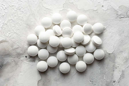 A handful of pills scattered on the table. A vial of medicines. Marble surface. Medicines.の写真素材