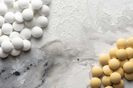 A handful of pills scattered on the table. A vial of medicines. Marble surface. Medicines.の写真素材