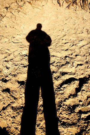 The shadow men standing against the Sun on the sand の写真素材