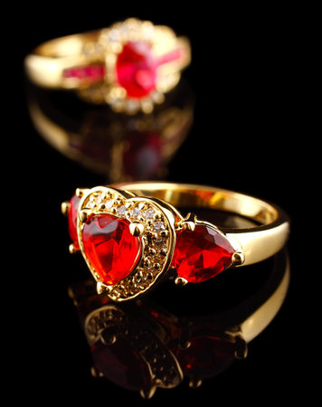 Gold rings with diamonds, on black with reflectionの写真素材