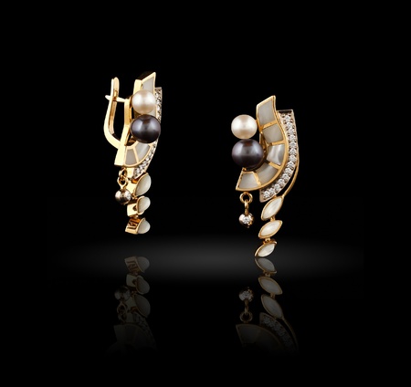 Pair of gold earrings on black background の写真素材
