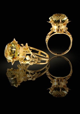Gold ring with brilliants and gem on a black background の写真素材
