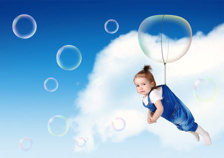 Funny child fly on soap bubble, flight creative conceptの写真素材