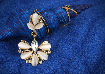 Jewelry pendant with nacre and diamonds on blue seashell background