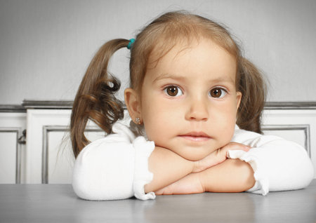 Porteait of serious dreaming child girl, in room