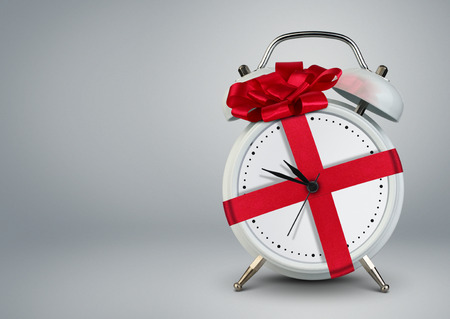 Clock in gift ribbon, time to gift cocept, copy space.の写真素材