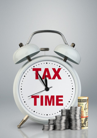 Alarm clock with money, tax time concept の写真素材