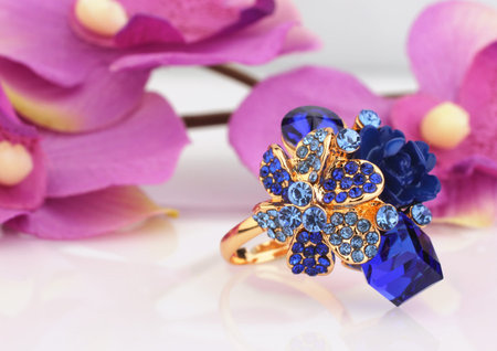 Jewellery ring with blue gems and flower Archidea backgroundの写真素材