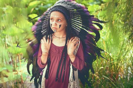 a young native of the Americas in the head cleaning of the Indian river looks upwards in a large plan on the background of a green lotus lakeの写真素材