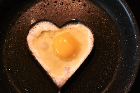 scrambled eggs in a heart-shaped frying panの写真素材