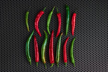hot green pepper and red chili on a dark background close uprightの写真素材