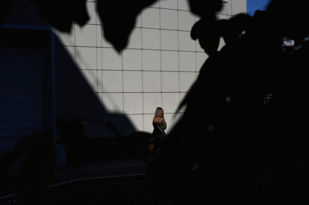 Girl standing near the wall with her back to the camera filmed horizontally