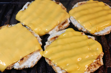 chicken cutlets for burgers with grilled cheese on top of close-up horizontallyの写真素材