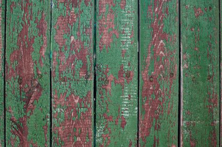 background of an old wooden fence with green cracked paint for writing textsの写真素材
