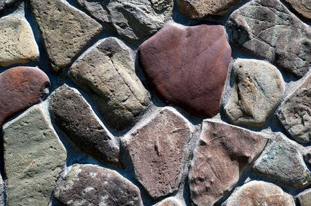 of different stones and sizes, the stone wall is very close-up horizontallyの写真素材