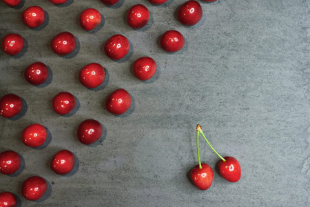 composition of cherries on a black stone background