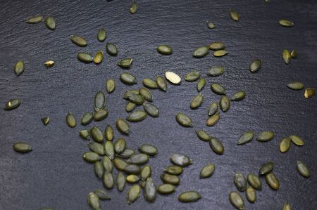 green pumpkin seeds on a black backgroundの写真素材