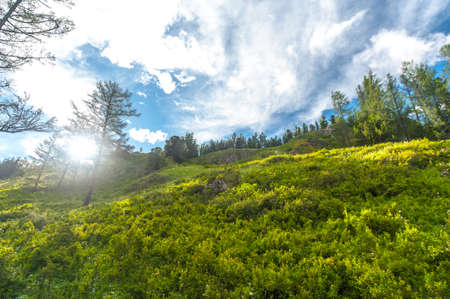 mountainous terrain and blue sky with rays of sunの写真素材