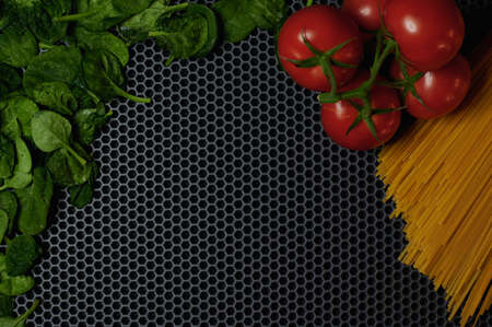 tomato spinach spaghetti on a dark background top close-up place for insertionの写真素材