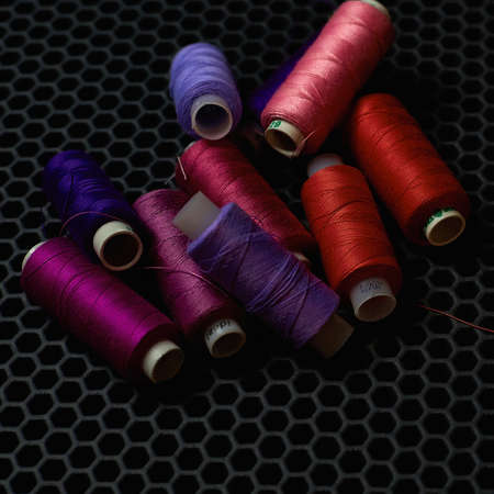 close-up multicolored threads on a dark background from aboveの写真素材