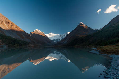 lake in the mountains with tops in the snow horizontally close-upの写真素材