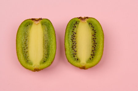 sliced â€‹â€‹kiwi on a light pink background close-up in the center horizontal photo