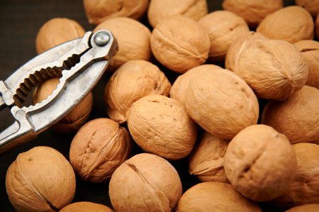 vintage nutcracker and a lot of walnuts on a dark wood background close-up top viewの写真素材