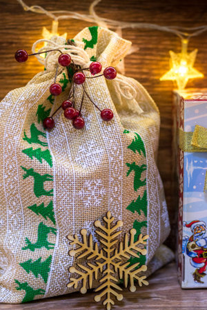 Bag with Christmas gifts, illuminated with garlands.