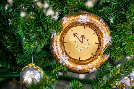 Christmas watch with a winter decoration on the Christmas fir. Happy new year concept.の写真素材
