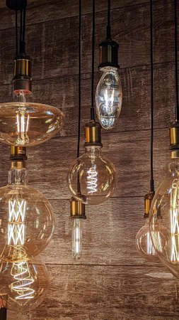 Burning light bulbs with original beautiful spirals on a warm brown background. Disain, beauty and comfort indoorsの写真素材