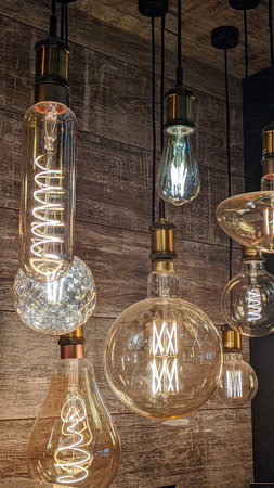 Burning light bulbs with original beautiful spirals on a warm brown background. Disain, beauty and comfort indoorsの写真素材