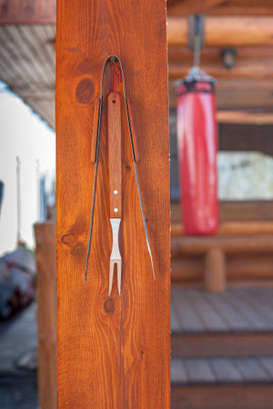 Barbecue kebab accessories: fork and chips on a wooden beamの写真素材