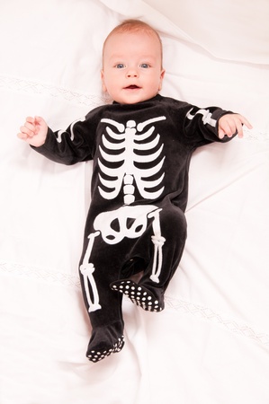Cute baby portrait in funny skeleton suit isolated on white background の写真素材