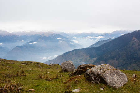view of the valley in himalayan mountains covered with cloudsの写真素材